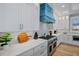 The luxury kitchen features marble countertops, a blue range hood, and modern stainless appliances at 135 Avenida Veneccia, Sarasota, FL 34242