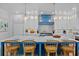 The luxury kitchen features a marble island, a blue range hood, and modern white cabinets at 135 Avenida Veneccia, Sarasota, FL 34242
