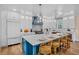 The luxury kitchen features a marble island, a blue range hood, and modern white cabinets at 135 Avenida Veneccia, Sarasota, FL 34242