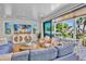 Cozy living room with a large TV, wicker chairs, and sliding glass doors to the balcony at 135 Avenida Veneccia, Sarasota, FL 34242