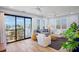 Bright living room with ocean views, a striped sofa, and access to an outdoor balcony at 135 Avenida Veneccia, Sarasota, FL 34242