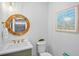 Stylish powder room featuring a unique round mirror, modern fixtures, and decor at 135 Avenida Veneccia, Sarasota, FL 34242