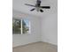 Spacious carpeted bedroom with a ceiling fan and window offering views of the yard at 1370 Mccrory St, North Port, FL 34286