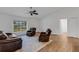 Bright living room with wood-look tile flooring and comfortable brown seating at 1370 Mccrory St, North Port, FL 34286