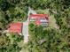 Sprawling estate with a red roof, solar panels, pool, and garage surrounded by lush greenery at 1401 Pelican Ln, North Port, FL 34286