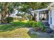 Lush green lawn, trees and colorful flowers adorn the home's backyard at 1516 Red Oak Ln, Port Charlotte, FL 33948