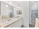 Bathroom features double sinks, a large mirror, and walk-in shower, creating a serene space at 1516 Red Oak Ln, Port Charlotte, FL 33948