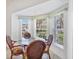 Sunlit breakfast nook with a glass-top table and seating for four, nestled in a bay window at 1516 Red Oak Ln, Port Charlotte, FL 33948