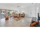 Living room with tile floors, a ceiling fan, and patio doors leading to the screened-in patio at 1516 Red Oak Ln, Port Charlotte, FL 33948