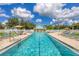 Beautiful outdoor pool surrounded by lounge chairs, umbrellas, and a charming pool house at 1516 Red Oak Ln, Port Charlotte, FL 33948