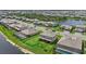 Aerial view shows homes with screened enclosures and a lake as part of a planned community at 15315 Golden Beam Pl, Bradenton, FL 34211