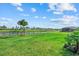 Expansive back yard features a meticulously maintained lawn, palm trees, and tranquil water views at 15315 Golden Beam Pl, Bradenton, FL 34211