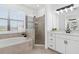 Bright bathroom with soaking tub, glass shower, and modern vanity with white cabinets at 15315 Golden Beam Pl, Bradenton, FL 34211