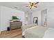 A neutral bedroom featuring hardwood floors, a ceiling fan, and a gray dresser with a television at 15315 Golden Beam Pl, Bradenton, FL 34211