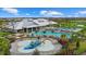Aerial view of the community's splash pad, pool, and amenities, surrounded by lounge chairs and palm trees at 15315 Golden Beam Pl, Bradenton, FL 34211