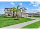 Beautiful two-story home with a well-manicured lawn and lush landscaping under a cloudy sky at 15315 Golden Beam Pl, Bradenton, FL 34211