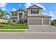 Charming two-story home featuring a three-car garage, attractive landscaping, and a paved driveway at 15315 Golden Beam Pl, Bradenton, FL 34211