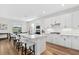 Well-appointed kitchen with white cabinets, stainless steel appliances, center island with bar seating, and views of the dining area at 15315 Golden Beam Pl, Bradenton, FL 34211