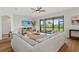Inviting living room boasts wood floors, a neutral color palette, comfortable sofa, and large windows offering views of the backyard at 15315 Golden Beam Pl, Bradenton, FL 34211