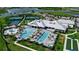 Stunning aerial view of community amenities including pools, tennis courts, and clubhouse by the lake at 15607 White Linen Dr, Bradenton, FL 34211