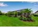 Expansive backyard showcasing a screened-in lanai with pool, lush landscaping and tropical palms at 15607 White Linen Dr, Bradenton, FL 34211