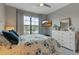 This bedroom has a large window, ceiling fan, dresser and queen-size bed at 15607 White Linen Dr, Bradenton, FL 34211