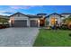 Charming single-story home with a three-car garage, paver driveway and walkway, and well-maintained landscaping at 15607 White Linen Dr, Bradenton, FL 34211