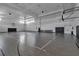 Full-sized indoor gymnasium featuring basketball hoops and a hardwood floor at 15607 White Linen Dr, Bradenton, FL 34211