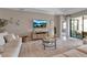 Bright living room featuring comfortable seating, modern décor, and sliding glass doors leading to patio at 15607 White Linen Dr, Bradenton, FL 34211