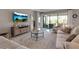 Living room with tile flooring, comfy seating, neutral tones, and a view of the patio at 15607 White Linen Dr, Bradenton, FL 34211