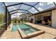 Enjoy the screened pool with attached spa, outdoor kitchen, and lounge space creating an ideal backyard retreat at 15607 White Linen Dr, Bradenton, FL 34211