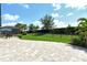 View of backyard featuring large stone paver patio, green grass and landscaping at 1919 Woodleaf Hammock Ct, Bradenton, FL 34211