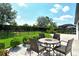Backyard features a stone patio with table, chairs, lush lawn and landscaping at 1919 Woodleaf Hammock Ct, Bradenton, FL 34211