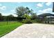 Fenced in backyard with stone paver patio, green grass and lush landscaping at 1919 Woodleaf Hammock Ct, Bradenton, FL 34211