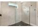 Modern shower with stylish tile, a glass enclosure, a window, and black pebble flooring at 1919 Woodleaf Hammock Ct, Bradenton, FL 34211