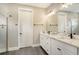 Elegant bathroom featuring double sinks, quartz countertops, white cabinets, and a walk-in glass shower at 1919 Woodleaf Hammock Ct, Bradenton, FL 34211
