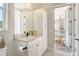 Bright bathroom with white cabinets, a quartz countertop, black fixtures, and an open doorway to an outdoor area at 1919 Woodleaf Hammock Ct, Bradenton, FL 34211