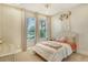 Cozy bedroom with neutral tones, a queen-sized bed, decorative floral accents, and lots of natural light from two windows at 1919 Woodleaf Hammock Ct, Bradenton, FL 34211
