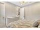Bright bedroom with a white dresser, neutral walls, light-colored floors, and an open doorway to another room at 1919 Woodleaf Hammock Ct, Bradenton, FL 34211
