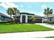 Beautiful single-story home with tropical landscaping, well-manicured lawn, and a two-car garage at 1919 Woodleaf Hammock Ct, Bradenton, FL 34211
