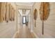 Long hallway with wood floors, modern wall decor, shiplap, and a coffered ceiling at 1919 Woodleaf Hammock Ct, Bradenton, FL 34211