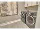 Convenient laundry room featuring front loading washer and dryer, tiled floor and cabinets for storage at 1919 Woodleaf Hammock Ct, Bradenton, FL 34211