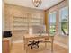 Elegant home office featuring custom wallpaper, built-in shelving, and a bright window at 1919 Woodleaf Hammock Ct, Bradenton, FL 34211