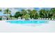 Lounge at the community pool, surrounded by lush landscaping, comfortable lounge chairs, and crystal clear water at 1919 Woodleaf Hammock Ct, Bradenton, FL 34211