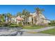 A beautiful home exterior featuring lush landscaping, mature palm trees, and unique architectural details at 2055 Gulf Of Mexico Dr # G2-108, Longboat Key, FL 34228