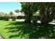 Manicured front yard with lush green grass and mature trees for shade at 2055 Gulf Of Mexico Dr # G2-108, Longboat Key, FL 34228