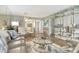 A combined living and dining area with contemporary furnishings, light wood floors, and a glass dining table set at 2055 Gulf Of Mexico Dr # G2-108, Longboat Key, FL 34228