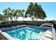 Inviting pool with clear blue water, surrounded by lush greenery and a secure fence, providing a serene escape at 2055 Gulf Of Mexico Dr # G2-108, Longboat Key, FL 34228