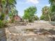Large backyard showcasing a unique brick-lined circular design and lush tropical landscaping at 2330 7Th W Ave, Bradenton, FL 34205