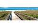 Inviting wooden boardwalk provides easy beach access through dunes; beautiful ocean view in background at 2330 7Th W Ave, Bradenton, FL 34205